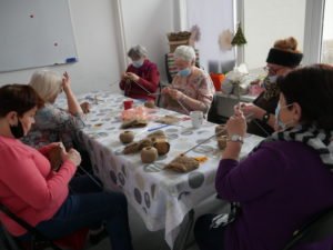 kobiety siedzą i robią na drutach myjki ze sznurka konopnego